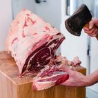 Carnicería - Charcutería Monedero hombre cortando trozo de carne